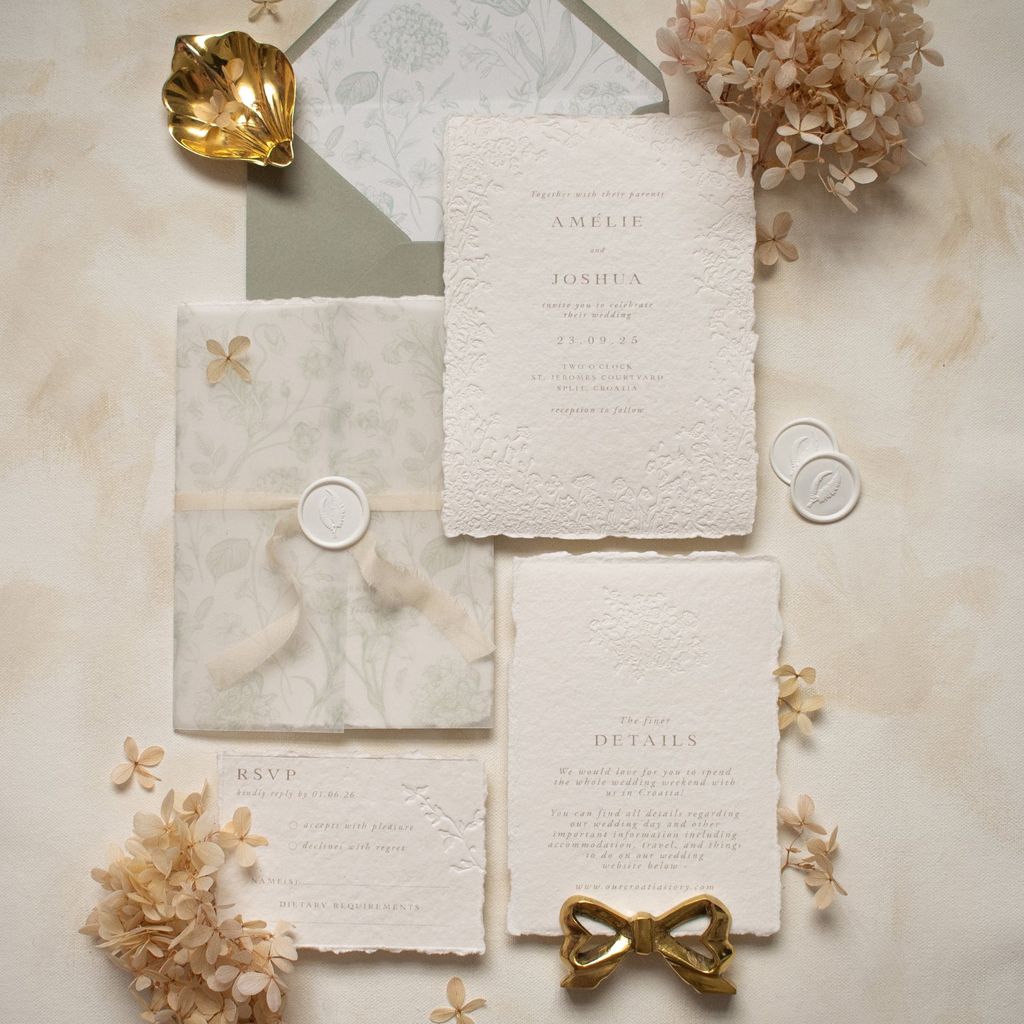 sage green floral wedding invitation suite with blind letterpress floral details on handmade cotton paper, sage green envelopes with floral envelope liners and matching sage green floral printed vellum wrap, tied with ivory hand dyed silk ribbon and white wax seal. Photographed on a neutral textured background with beige dried hydrangeas for styling