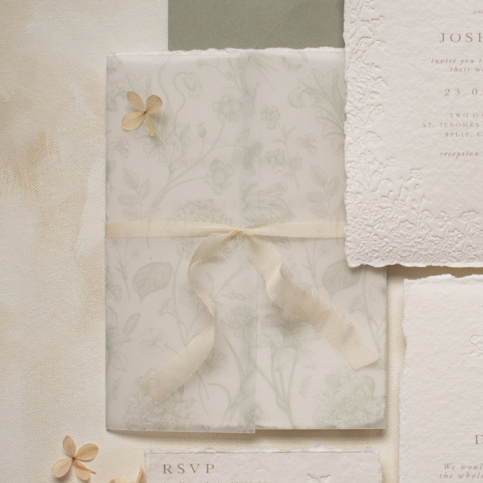sage green floral vellum wrap with hand dyed silk ivory ribbon and white wax seal for wedding invitations