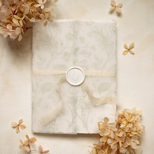 sage green floral vellum wrap with hand dyed silk ivory ribbon and white wax seal for wedding invitations