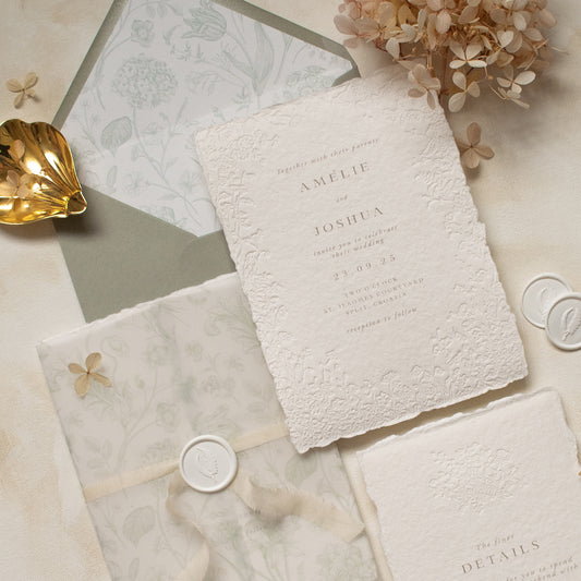 sage green floral vellum wrap with hand dyed silk ivory ribbon and white wax seal and floral letterpress wedding invitations on handmade cotton paper with dried flowers
